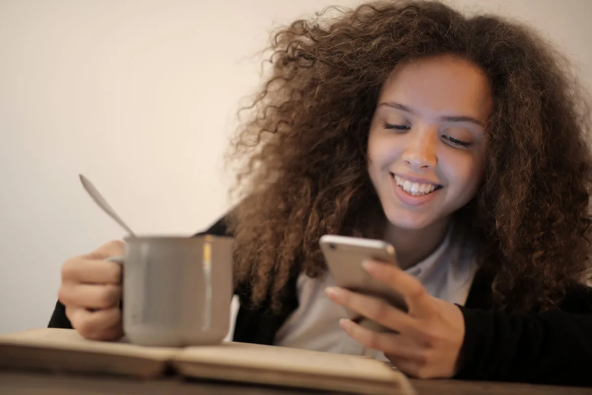 Client reading an appointment reminder text on her phone - the same-day reminder catches the no-show decision as it's being made