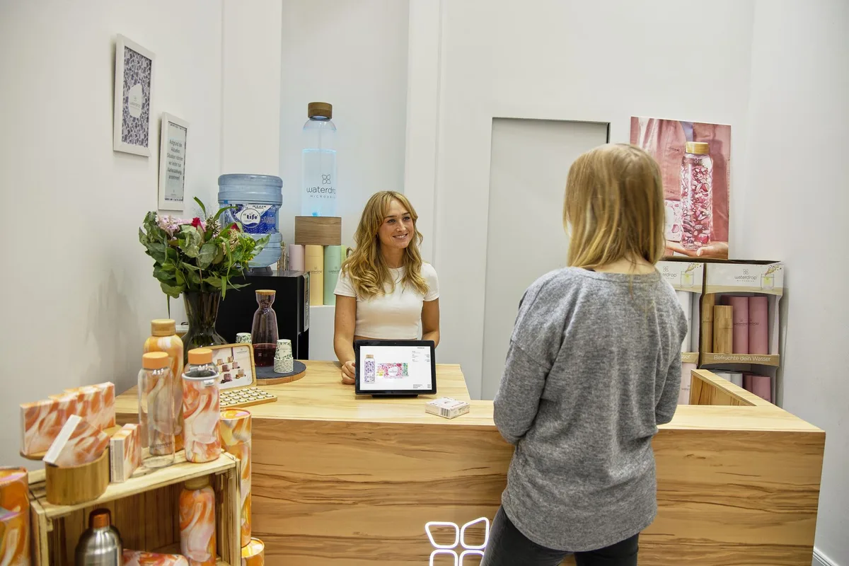 A salon front desk taking a booking - the phone-tag VoltsBook replaces with a booking page
